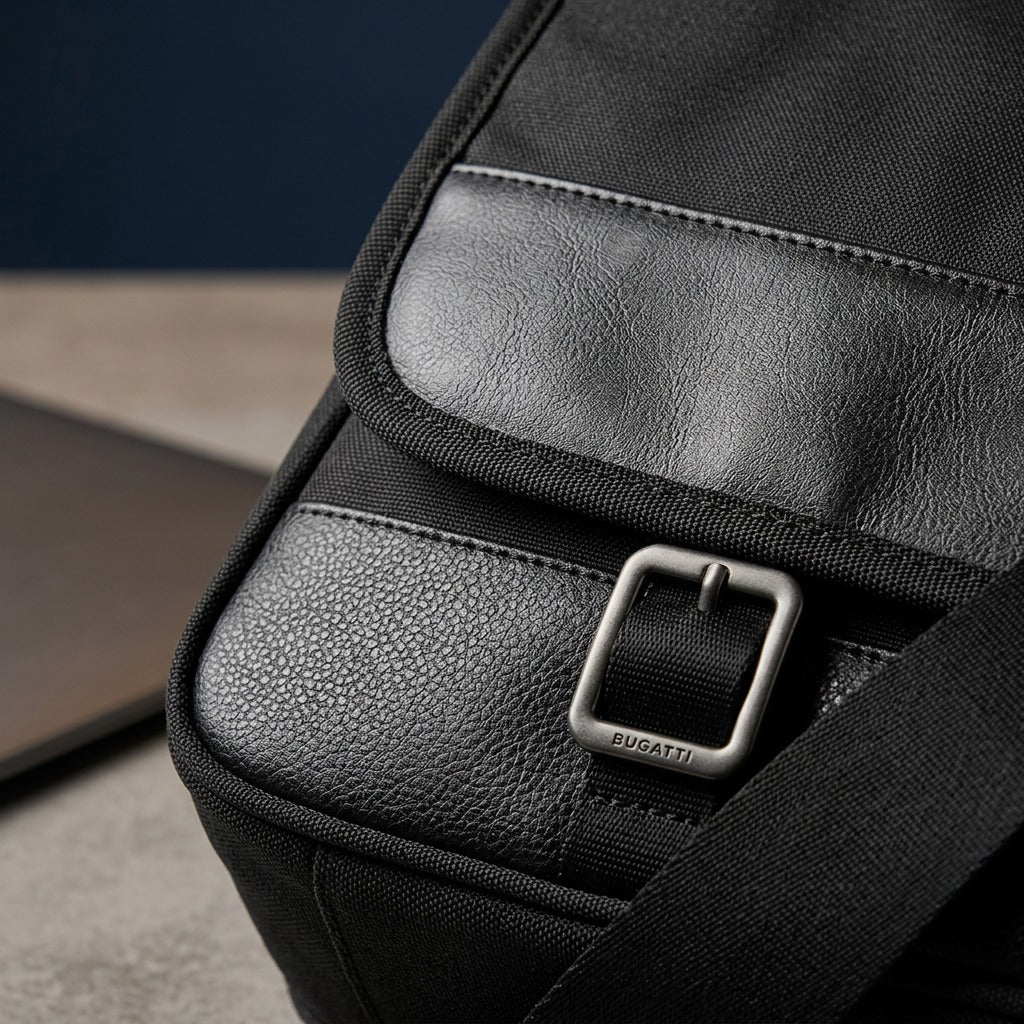 Macro detail of black pebble-grain vegan leather and gunmetal buckle on Bugatti Gregory briefcase.