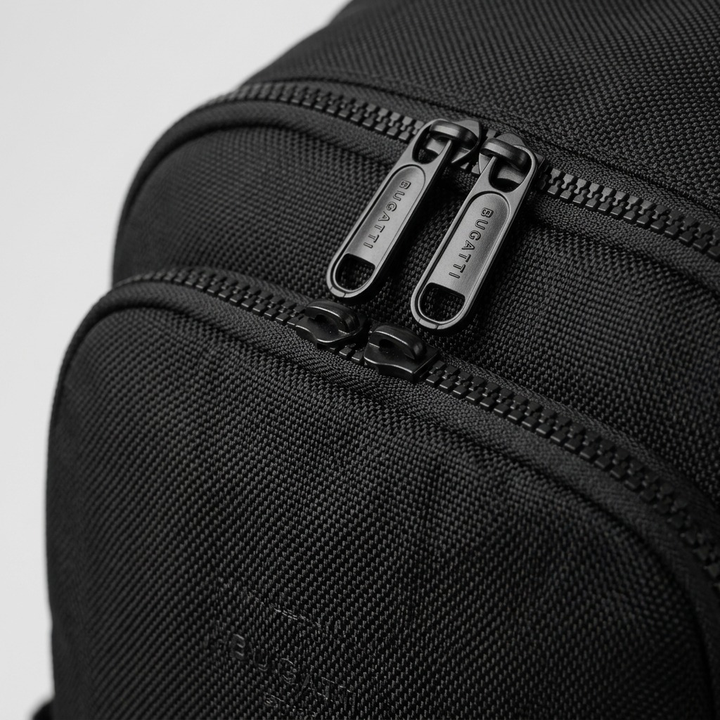 Macro detail of the Bugatti Madison Backpack showing durable black fabric and dual engraved zippers.