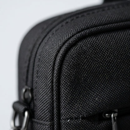 Macro detail of the black Nextech Nxt Poly laptop bag showing textured weave and durable stitching.