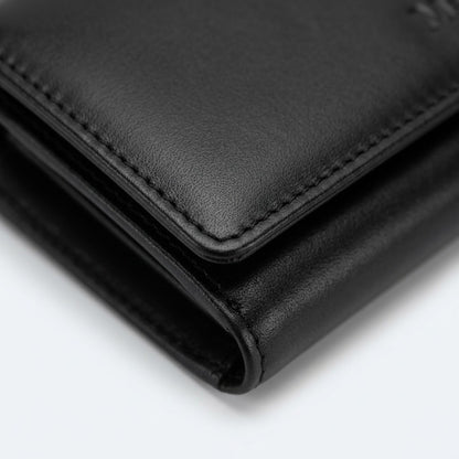Macro detail of the Mancini Equestrian-2 black leather wallet showing fine grain and stitching.